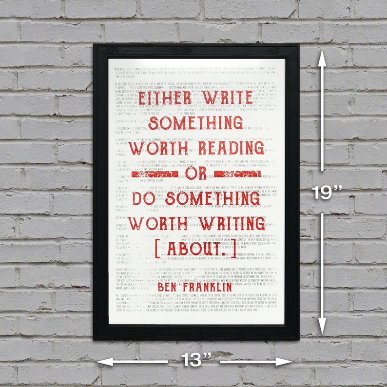 May include: A black framed print with a white background and red text. The text reads "Either write something worth reading or do something worth writing about." The quote is attributed to Ben Franklin. The print measures 13 inches wide by 19 inches tall.