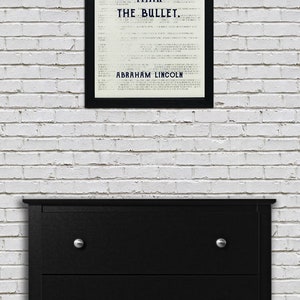 May include: A black framed print with a white background and black text that reads "The ballot is stronger than the bullet. Abraham Lincoln."