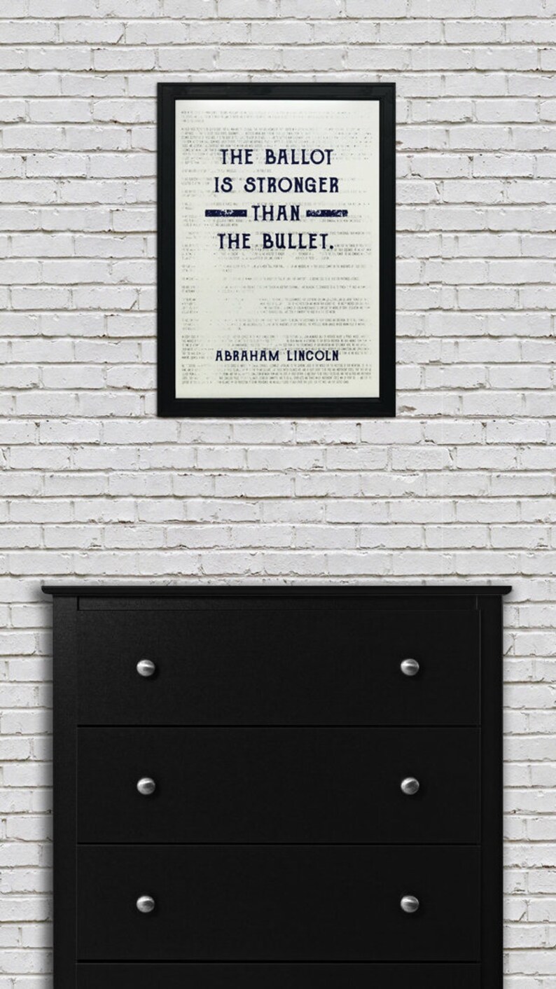May include: A black framed print with a white background and black text that reads "The ballot is stronger than the bullet. Abraham Lincoln."