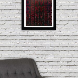 May include: A framed print with the word "DENVER" repeated multiple times in a red, outlined font on a black background.