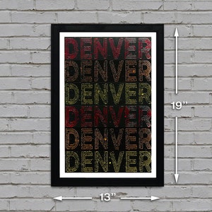 May include: A black framed print with the word "DENVER" repeated six times in a gradient of red, orange, and yellow on a black background. The print measures 13 inches wide by 19 inches tall.