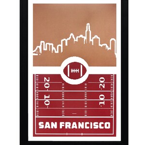 May include: A framed print with a red and white football field design. The print features a white outline of the San Francisco skyline and the text "SAN FRANCISCO".