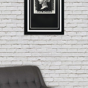 May include: A black and white framed print of a vintage postage stamp featuring a woman's profile and the text "POSTAGE ONE PENNY".