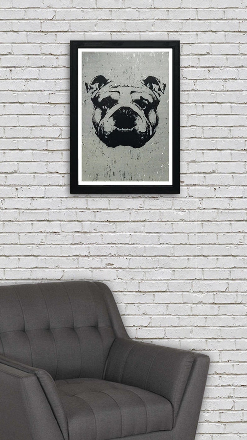 Puede incluir: Ilustraci&oacute;n en blanco y negro de la cara de un bulldog en un marco negro contra una pared de ladrillo blanco. La cara del bulldog est&aacute; centrada en el marco y tiene una expresi&oacute;n seria.