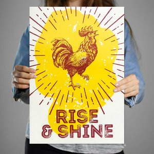 May include: A yellow and red poster with a rooster illustration and the text "Rise & Shine".