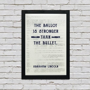 May include: A black framed print with a white background and blue text. The text reads "The ballot is stronger than the bullet. Abraham Lincoln."