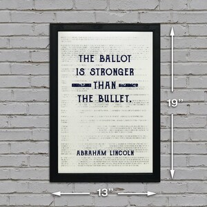May include: A black framed print with a white background and blue text. The text reads "The ballot is stronger than the bullet. Abraham Lincoln". The print measures 13 inches wide and 19 inches tall.