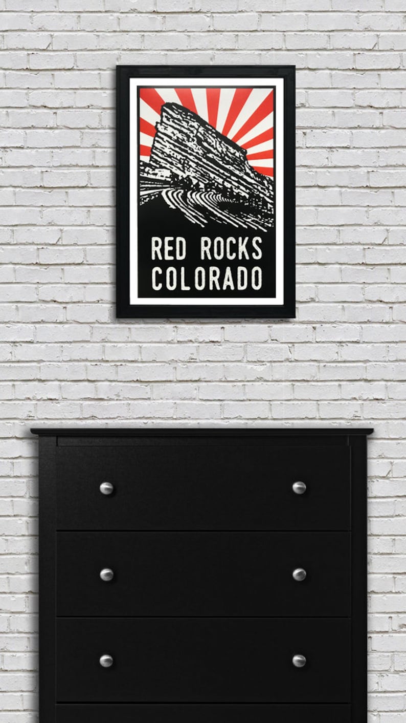 K&ouml;nnte beinhalten: Eine Schwarzwei&szlig;illustration des Red Rocks Amphitheaters in Morrison, Colorado. Die Illustration ist vor einem roten und wei&szlig;en Sonnenstrahlenhintergrund platziert. Der Text "RED ROCKS COLORADO" ist unter der Illustration gedruckt.