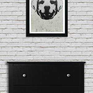 Puede incluir: Ilustraci&oacute;n en blanco y negro de la cara de un perro en un marco negro. El perro es un labrador retriever con una expresi&oacute;n feliz. La ilustraci&oacute;n est&aacute; sobre un fondo gris claro.
