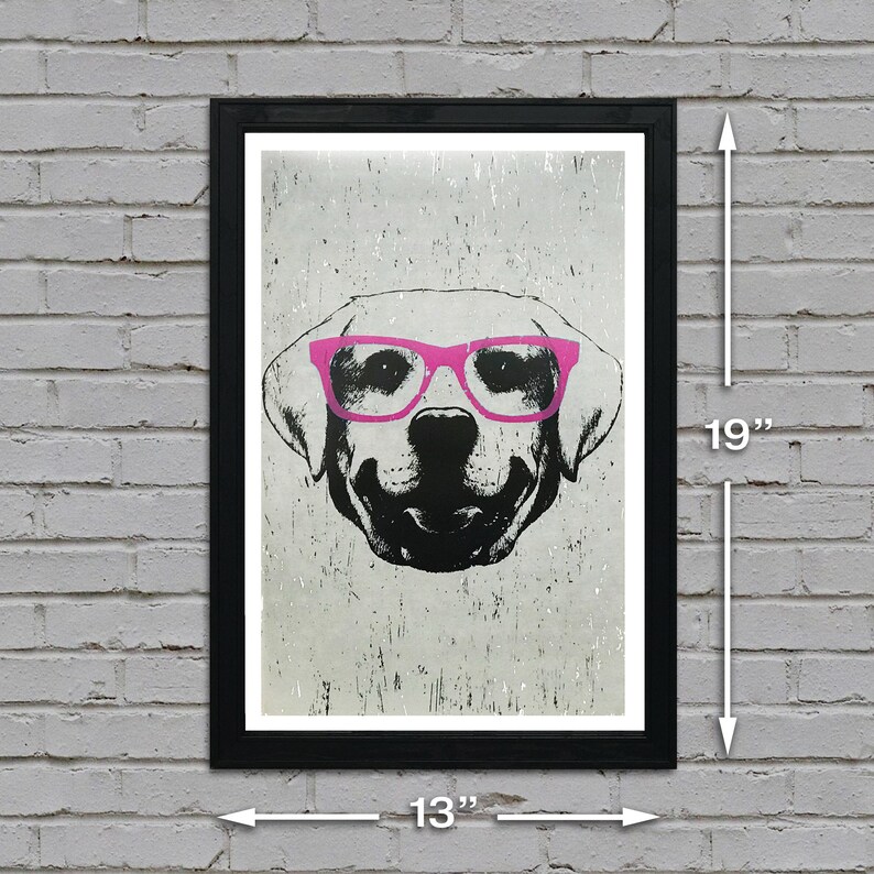 May include: A black and white illustration of a dog wearing pink glasses. The image is printed on a textured background and framed in a black frame. The frame measures 13 inches wide by 19 inches tall.