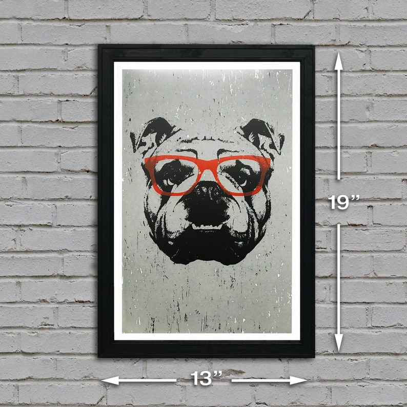 May include: A black framed print of a bulldog wearing red glasses. The print is 13 inches wide and 19 inches tall.