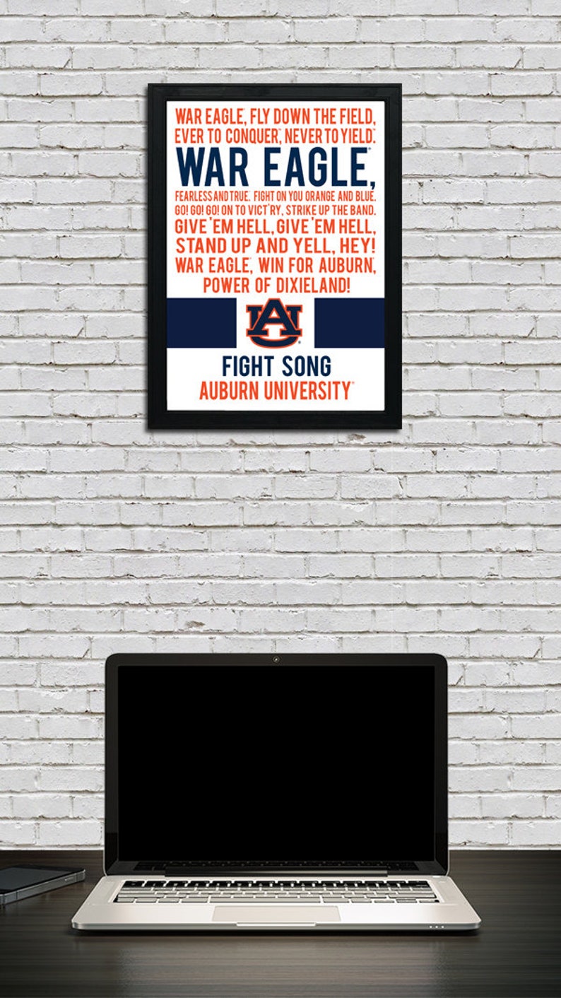 K&ouml;nnte beinhalten: Ein gerahmter Druck mit einem schwarzen Rahmen und einem wei&szlig;en Hintergrund. Der Druck zeigt die Textzeilen des Kampfliedes der Auburn University und das Logo der Auburn University in Orange und Blau. Der Text lautet "War Eagle, Fly Down the Field, Ever to Conquer, Never to Yield: War Eagle. Fearless and True. Fight on You Orange and Blue. Go! Go! Go! On to Victory, Strike Up the Band. Give 'Em Hell, Give 'Em Hell, Stand Up and Yell, Hey! War Eagle, Win for Auburn, Power of Dixieland!" Das Logo ist ein stilisiertes "A" mit einem Tigerkopf darin. Der Text "Fight Song" und "Auburn University" befindet sich unter dem Logo.