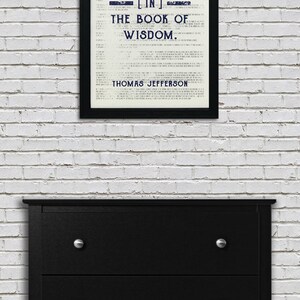 May include: A black framed print with a white background and blue text. The text reads "Honesty is the first chapter [in] the book of wisdom. Thomas Jefferson."