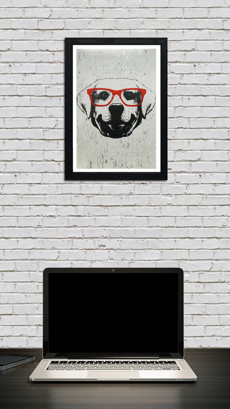 May include: A black and white illustration of a dog wearing red glasses. The dog is looking directly at the viewer. The illustration is framed in a black frame and hanging on a white brick wall.