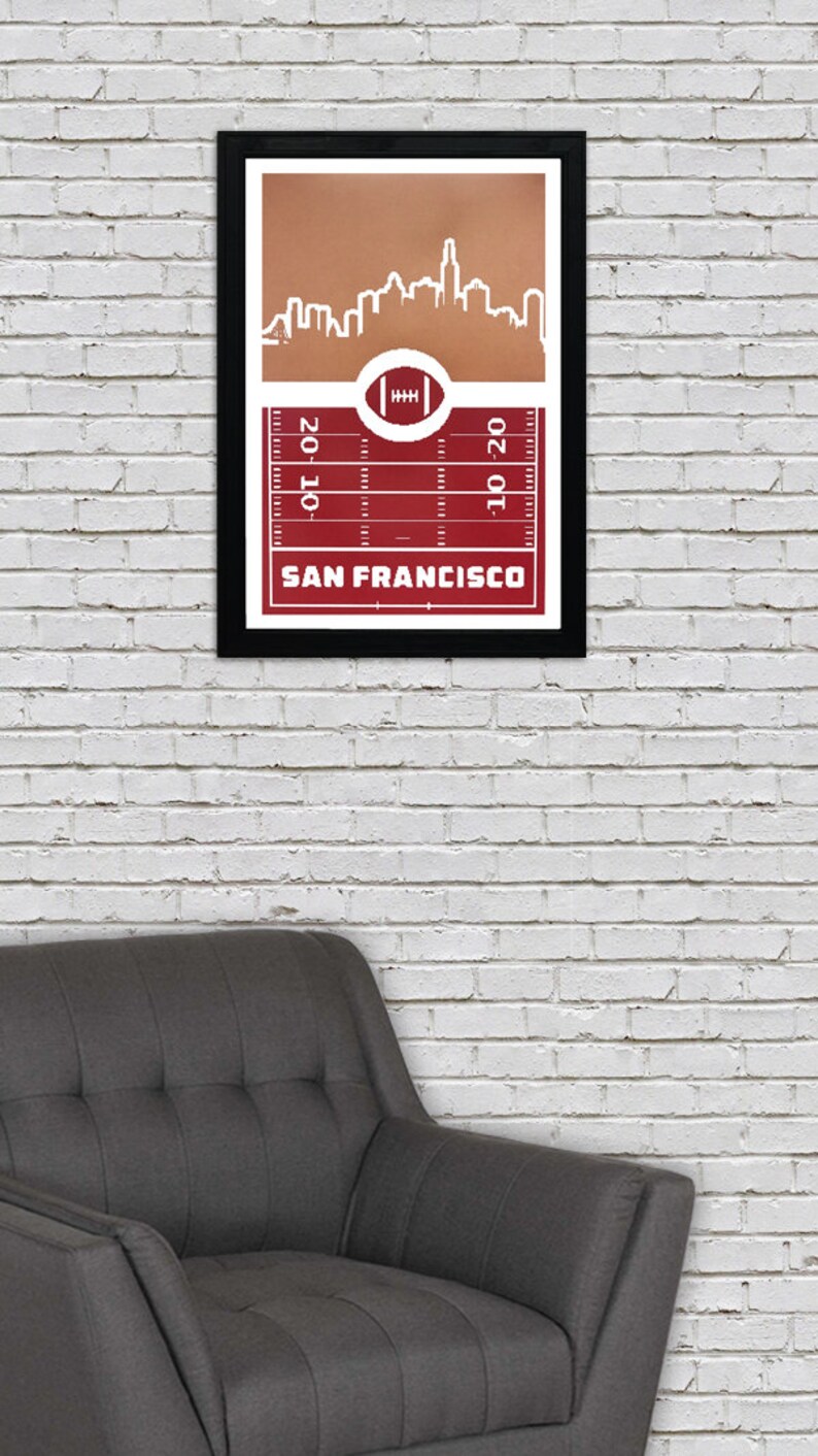 May include: A framed print of a red and white football field with a white silhouette of the San Francisco skyline. The text "SAN FRANCISCO" is printed below the field.