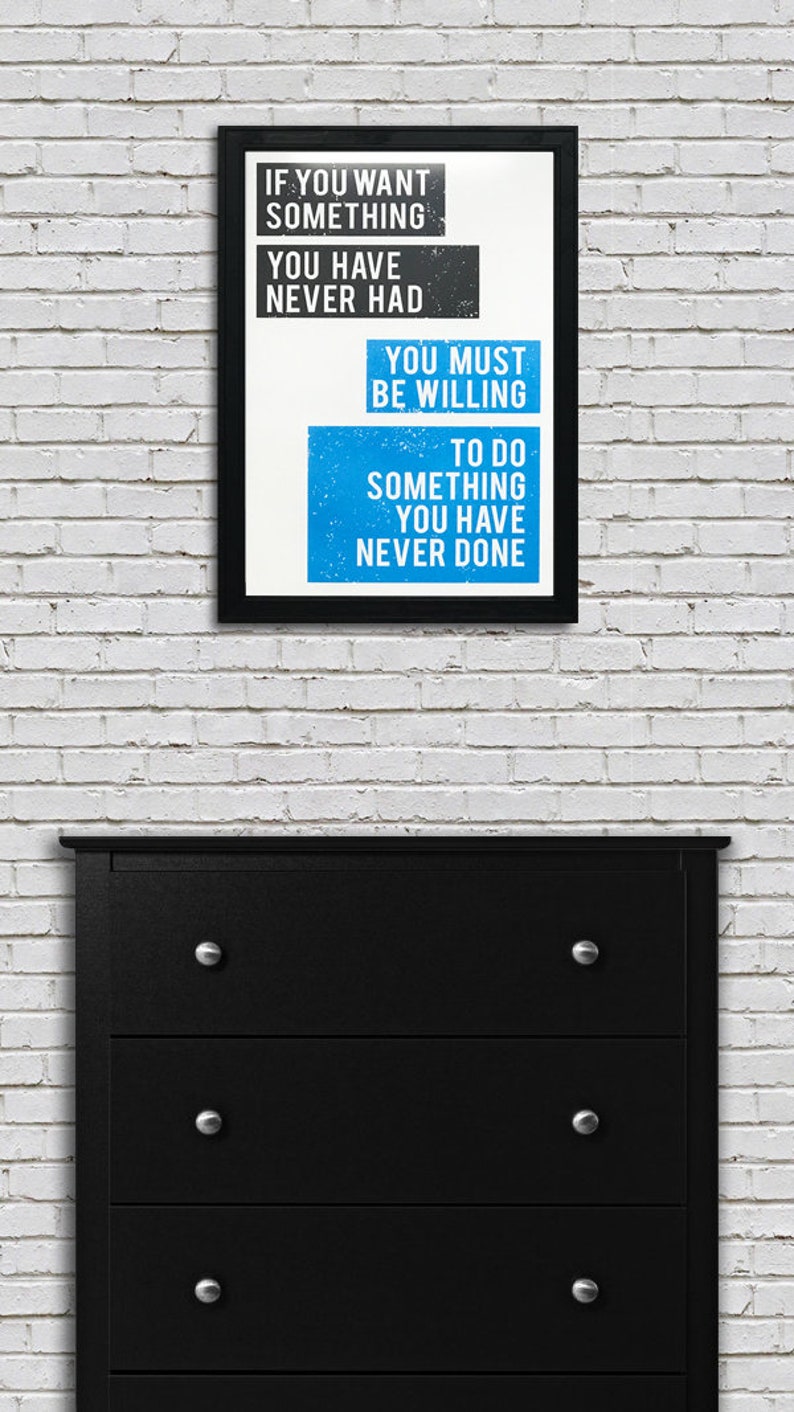 May include: A black framed motivational poster with white text on a blue background. The text reads "If you want something you have never had you must be willing to do something you have never done."