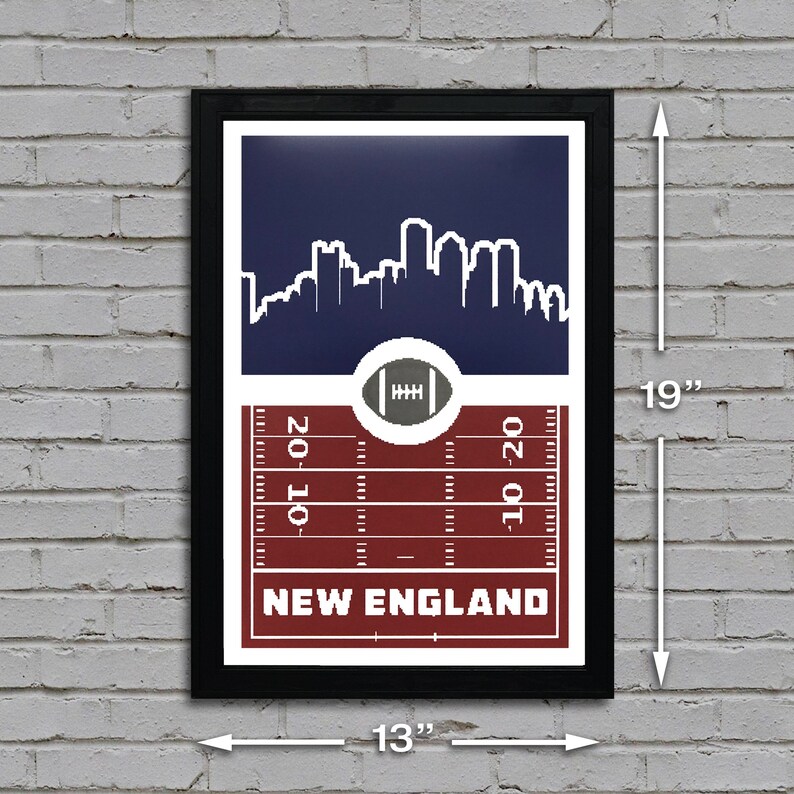 May include: A framed print of a football field with a skyline of New England in the background. The print is 13 inches wide and 19 inches tall. The field is red and white, with the words "NEW ENGLAND" printed in white at the bottom.