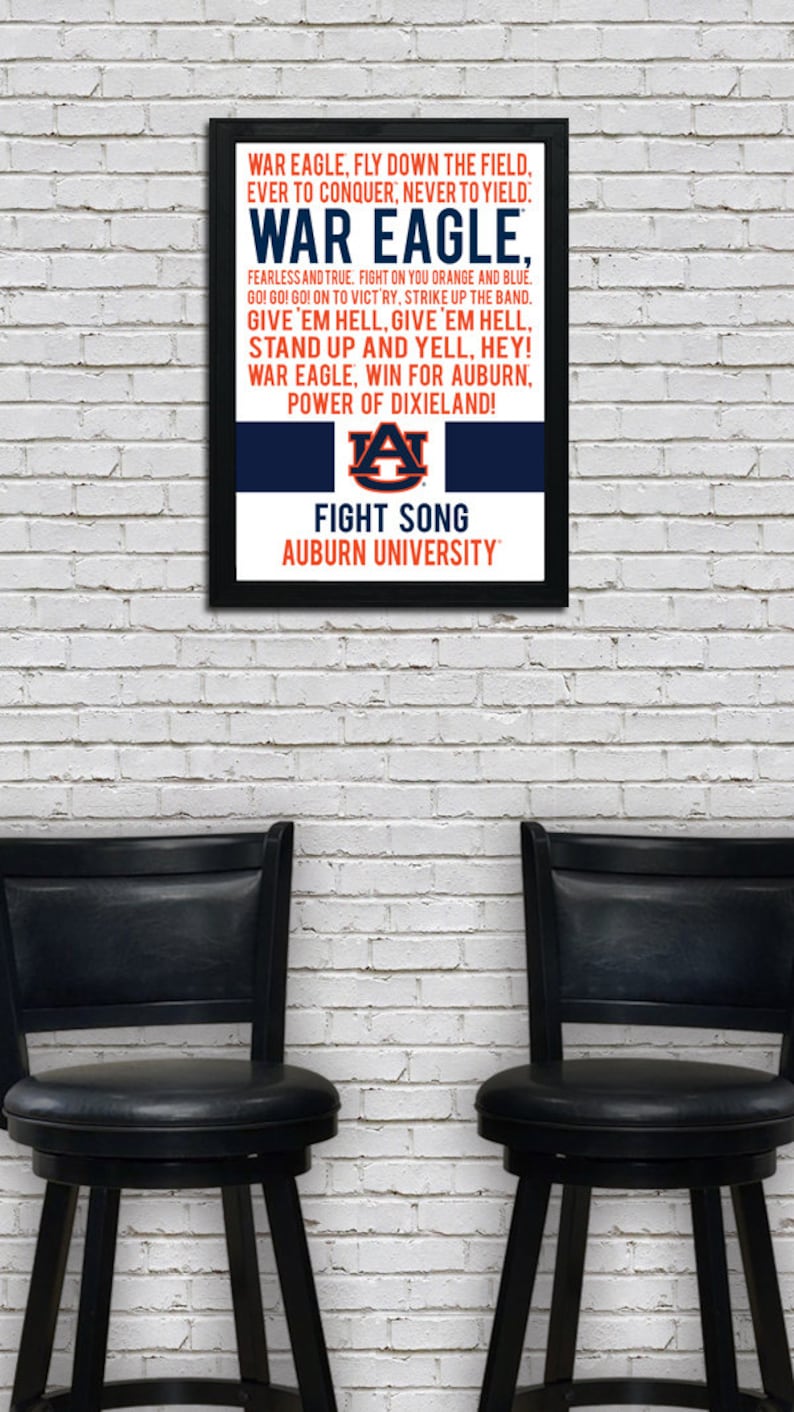 K&ouml;nnte beinhalten: Ein gerahmter Druck des Kampfliedtextes der Auburn University. Der Text ist in schwarzer Schrift auf blauem Hintergrund mit einem orange-blauen Logo der Auburn University. Der Rahmen ist schwarz.