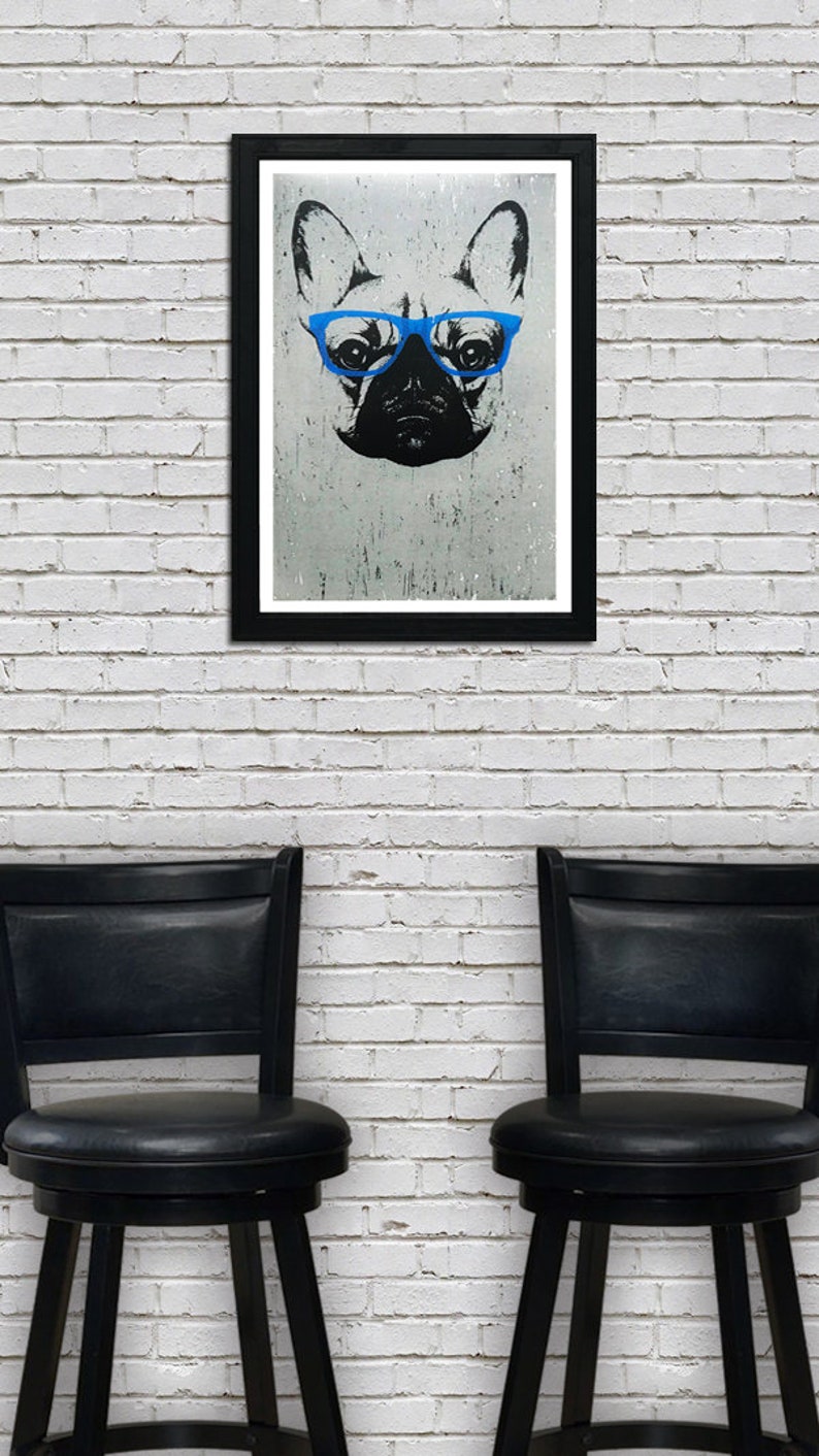 May include: A black and white illustration of a French bulldog wearing blue glasses, framed in a black frame, hanging on a white brick wall. Two black bar stools are in the foreground.