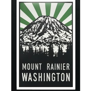 May include: Black and white illustration of Mount Rainier with a green sunburst behind it. The text "MOUNT RAINIER WASHINGTON" is below the mountain.