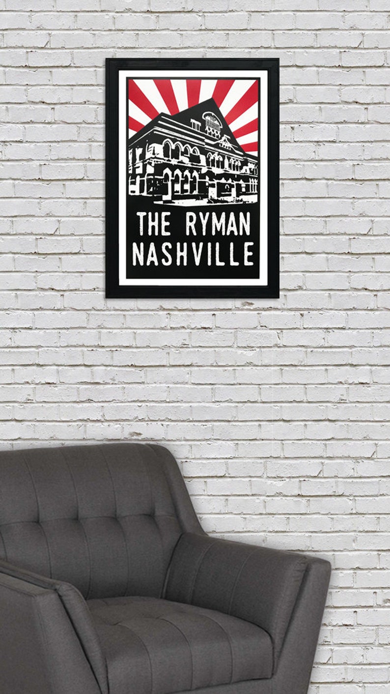 May include: Black and white illustration of the Ryman Auditorium in Nashville, Tennessee. The building is depicted with a red and white sunburst behind it. The text "The Ryman Nashville" is printed below the building.