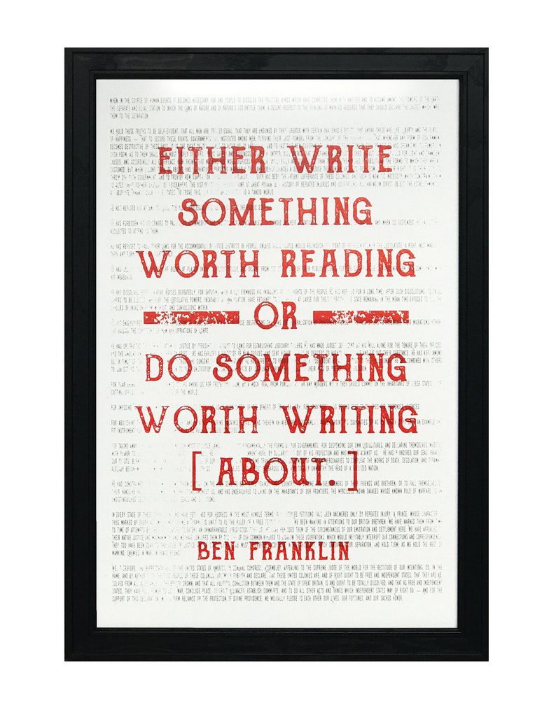 May include: A black framed print with a white background and red text. The text reads "Either write something worth reading or do something worth writing about." The quote is attributed to Ben Franklin.