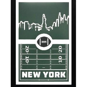 Puede incluir: Una impresi&oacute;n enmarcada con un fondo verde que presenta una silueta blanca del horizonte de la ciudad de Nueva York, un bal&oacute;n de f&uacute;tbol y un campo de f&uacute;tbol con l&iacute;neas de yarda. El texto "NEW YORK" est&aacute; impreso en blanco en la parte inferior de la impresi&oacute;n.