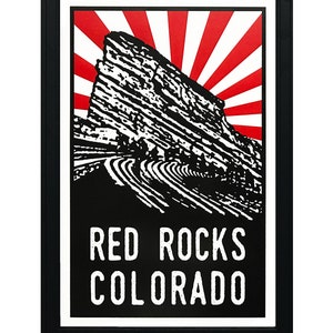 May include: Black and white illustration of Red Rocks Amphitheatre in Morrison, Colorado, with a red and white sunburst behind it. The text "RED ROCKS COLORADO" is below the illustration.