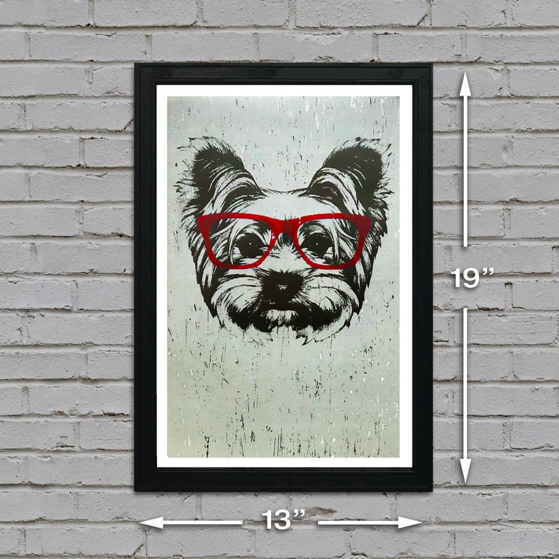May include: A black and white illustration of a Yorkshire Terrier wearing red glasses. The image is printed on a textured background and framed in a black frame. The print measures 13 inches wide by 19 inches tall.