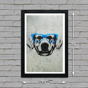 May include: A black framed print of a dog wearing blue glasses. The dog is a golden retriever with a white background. The print measures 13 inches wide by 19 inches tall.