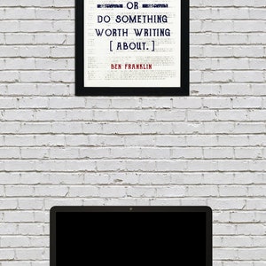 May include: A black framed print with a white background and blue text. The text reads "Either write something worth reading or do something worth writing about."  The quote is attributed to Ben Franklin.