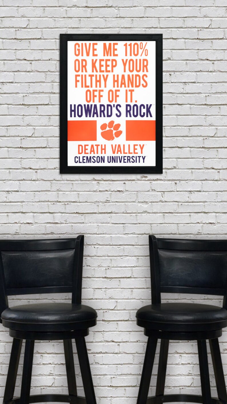 May include: A black framed poster with an orange and white background. The poster reads "Give me 110% or keep your filthy hands off of it. Howard's Rock. Death Valley. Clemson University."