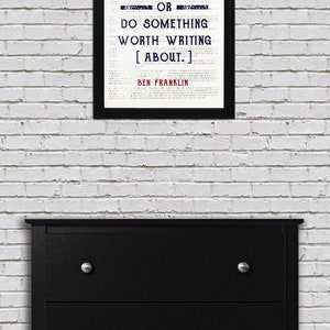 May include: Black and white framed print with a quote by Ben Franklin: "Either write something worth reading or do something worth writing about."