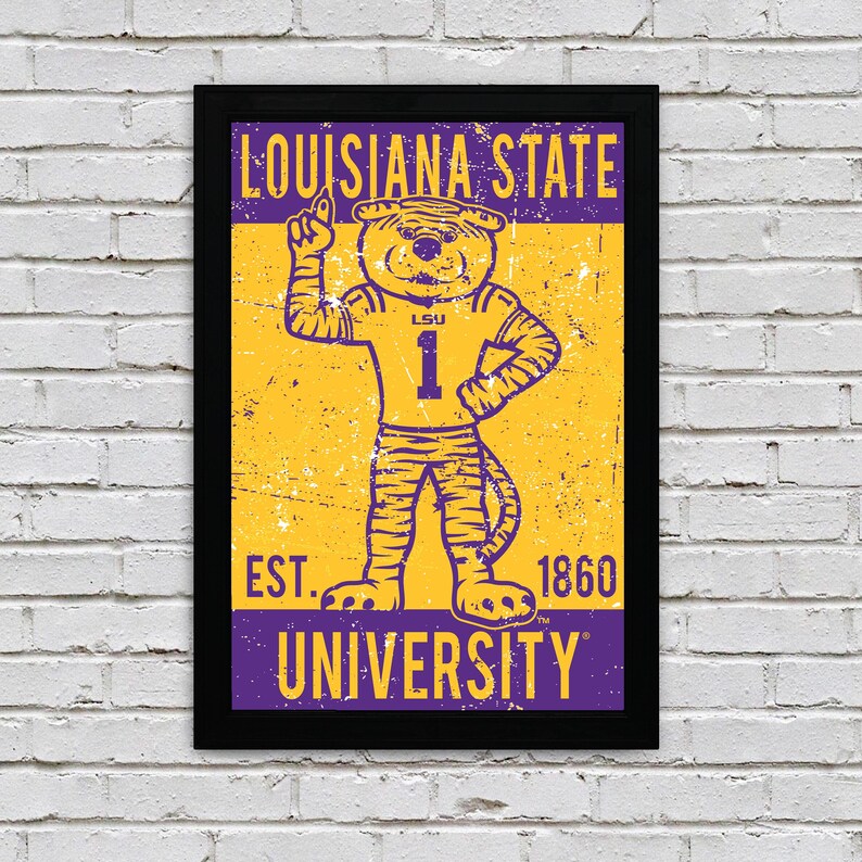 May include: Framed poster featuring the Louisiana State University mascot, a tiger wearing a purple jersey with the number 1. The poster has a distressed, vintage look with the words "LOUISIANA STATE UNIVERSITY" and "EST. 1860". The colour scheme is purple and gold.