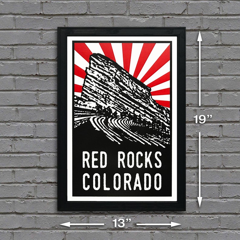 May include: Black and white poster with a red and white sunburst design. The poster features a stylized image of Red Rocks Amphitheatre in Colorado. The text "RED ROCKS COLORADO" is printed in white on a black background. The poster measures 13 inches wide by 19 inches tall.