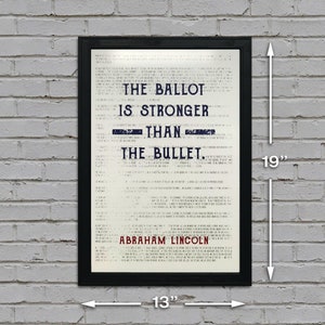 May include: A black framed print with a white background and blue text that reads "The Ballot is Stronger Than The Bullet. Abraham Lincoln". The print measures 13 inches wide by 19 inches tall.