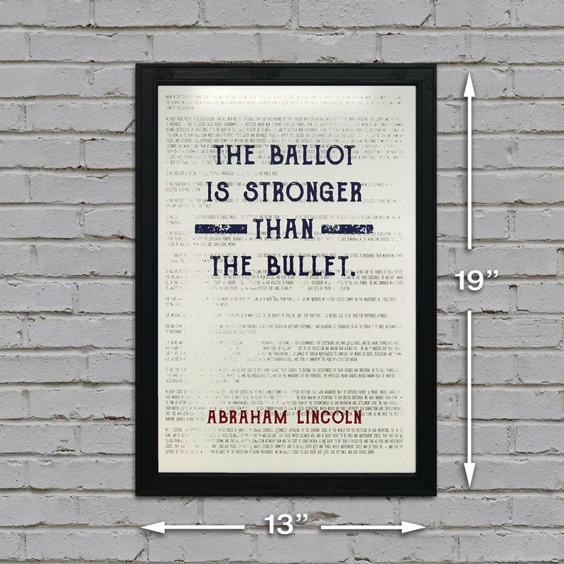 May include: A black framed print with a white background and blue text that reads "The Ballot is Stronger Than The Bullet. Abraham Lincoln". The print measures 13 inches wide by 19 inches tall.