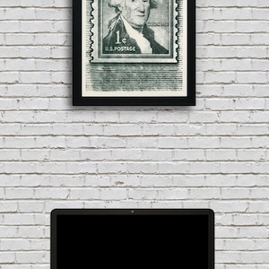 May include: A framed black and white print of a vintage US postage stamp featuring George Washington. The stamp is green and has the text "1&cent; U.S. POSTAGE" and "WASHINGTON".