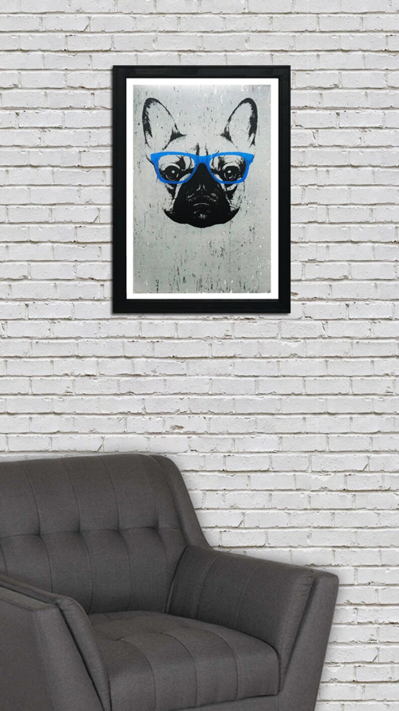 May include: A black and white illustration of a French bulldog wearing blue glasses. The image is framed in a black frame and is hanging on a white brick wall.