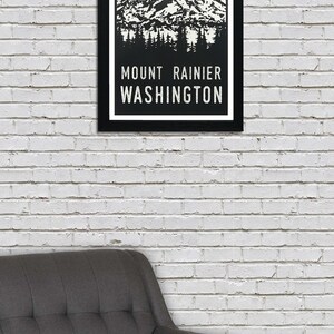 May include: A black framed poster with a green and white illustration of Mount Rainier, Washington. The text "MOUNT RAINIER WASHINGTON" is printed in white on a black background.