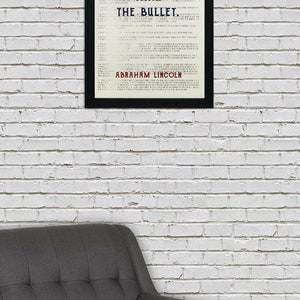 May include: A black framed print with a white background and black text that reads "The Ballot is Stronger Than The Bullet."  The text is in a vintage style font.  The quote is attributed to Abraham Lincoln at the bottom of the print.