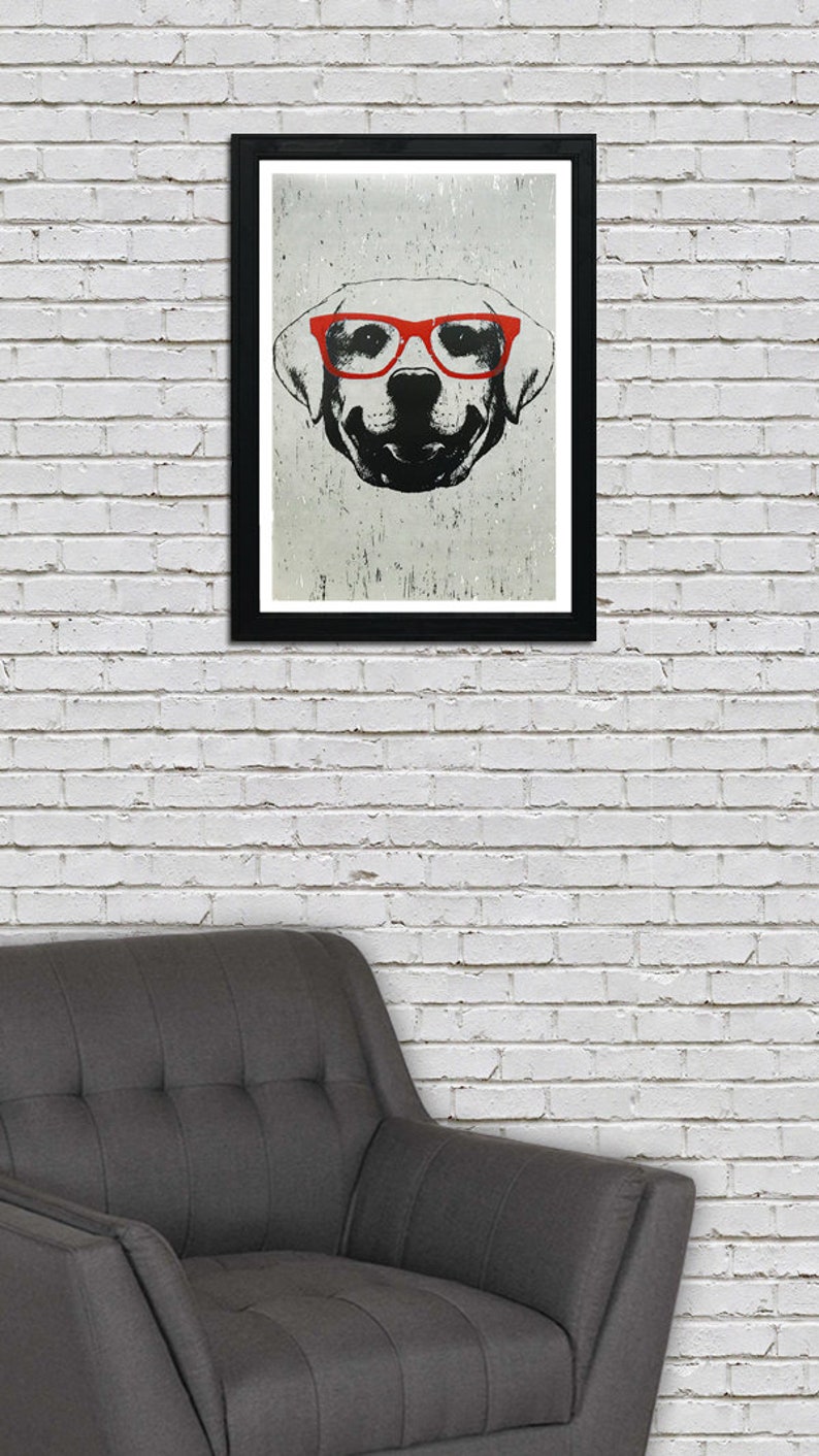 May include: A black and white illustration of a dog wearing red glasses. The dog is looking directly at the viewer. The illustration is framed in a black frame.