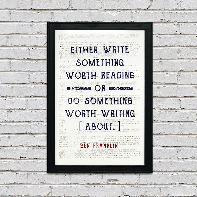 May include: A black framed print with a white background and blue text. The text reads "Either write something worth reading or do something worth writing about." The quote is attributed to Ben Franklin.