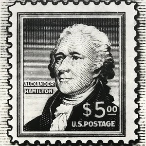 May include: Black and white stamp featuring a portrait of Alexander Hamilton with the text "ALEXANDER HAMILTON" and "$5.00 U.S. POSTAGE".