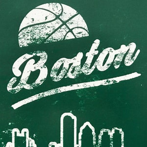 May include: A green chalkboard with white text that says "Boston" and a white basketball graphic. The bottom of the chalkboard shows a white outline of a city skyline.