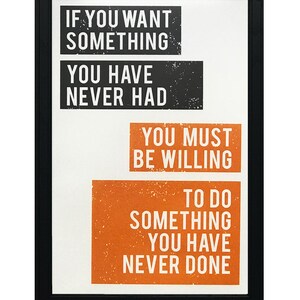 May include: Black framed motivational poster with white text on a white background. The text reads "If you want something you have never had you must be willing to do something you have never done."