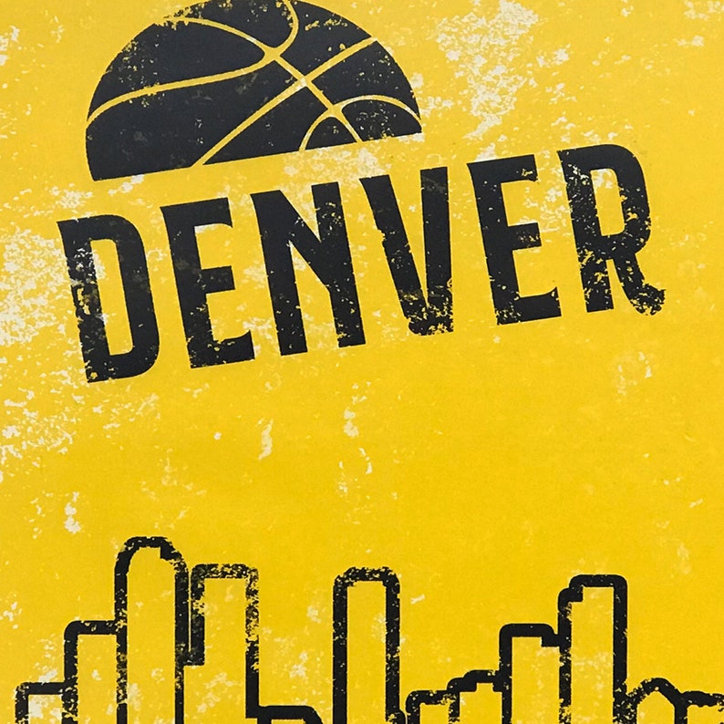 Puede incluir: Un fondo amarillo con un gr&aacute;fico de baloncesto negro y la palabra "DENVER" en texto negro. Debajo del texto, hay contornos negros de edificios.