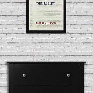 May include: A black framed print with a white background and black text that reads "The Ballot is Stronger Than The Bullet." The text is in a vintage font. The name "Abraham Lincoln" is printed in red at the bottom of the print.