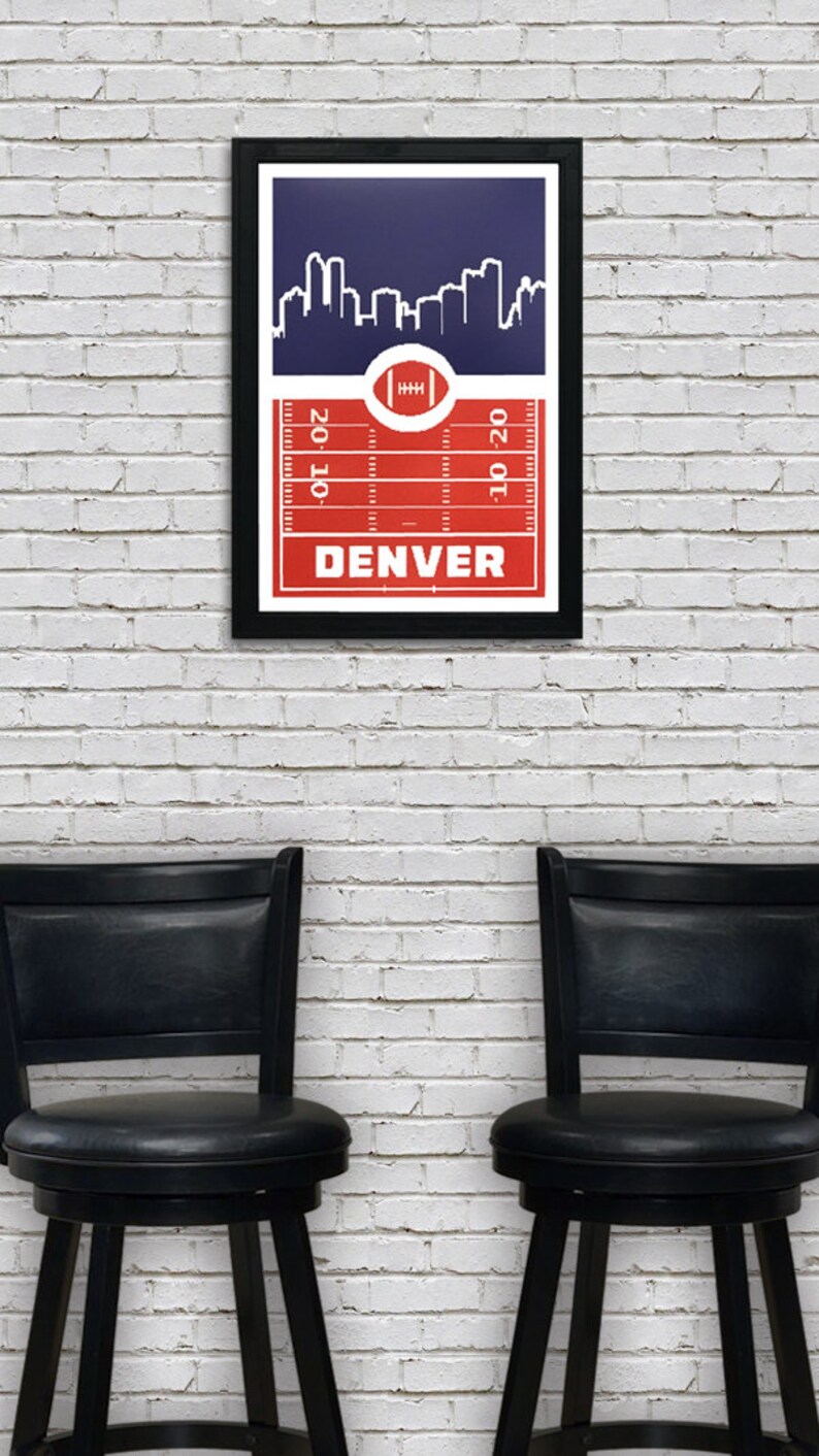 May include: A framed print with a red and white football field design and a blue skyline of Denver, Colorado. The text "DENVER" is printed in white at the bottom of the print.