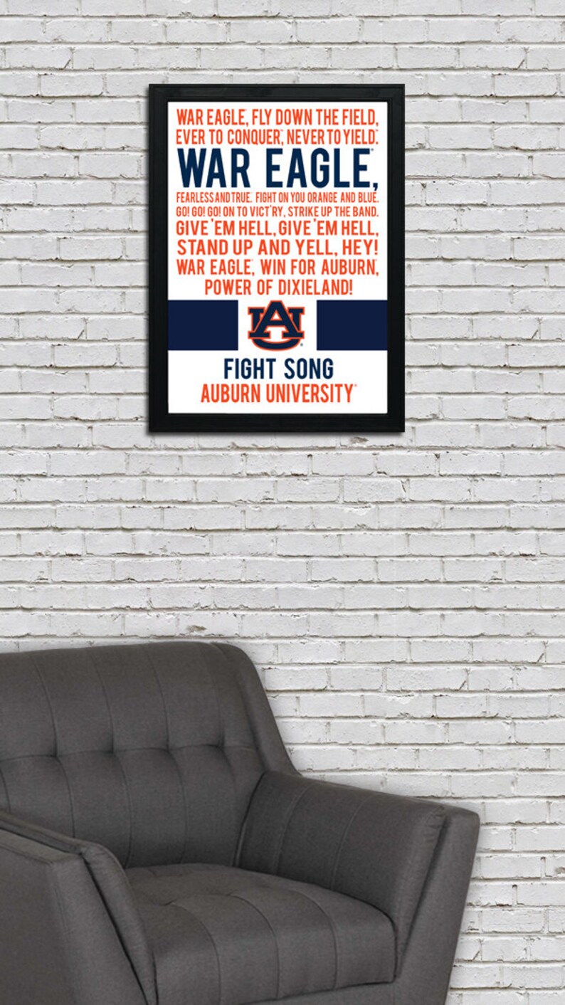 K&ouml;nnte beinhalten: Ein gerahmter Druck mit einem schwarzen Rahmen und einem wei&szlig;en Hintergrund. Der Druck zeigt den Kampfliedtext der Auburn University in blauem und orangefarbenem Text. Der Text enth&auml;lt die W&ouml;rter "War Eagle" und "Fight Song". Das Logo der Auburn University ist in der Mitte des Drucks abgebildet.